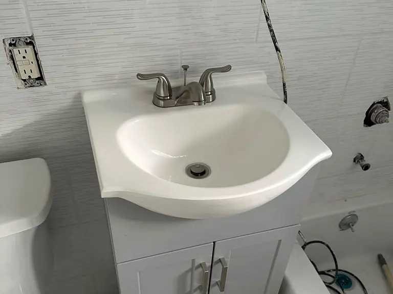 New chrome two-handle bathroom faucet installed on a white vanity sink — faucet installation and repair in New Jersey