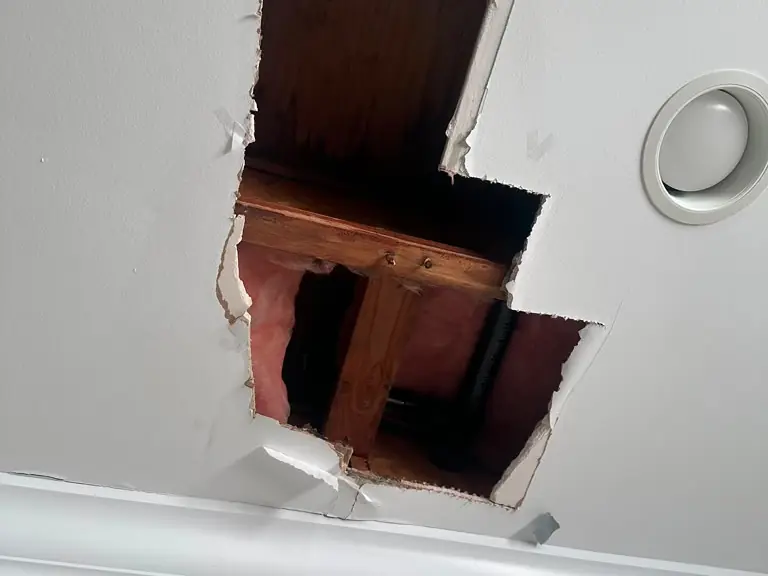 Ceiling opened to expose and locate a leaking drain pipe above the drywall — leak detection and repair in Absecon, NJ