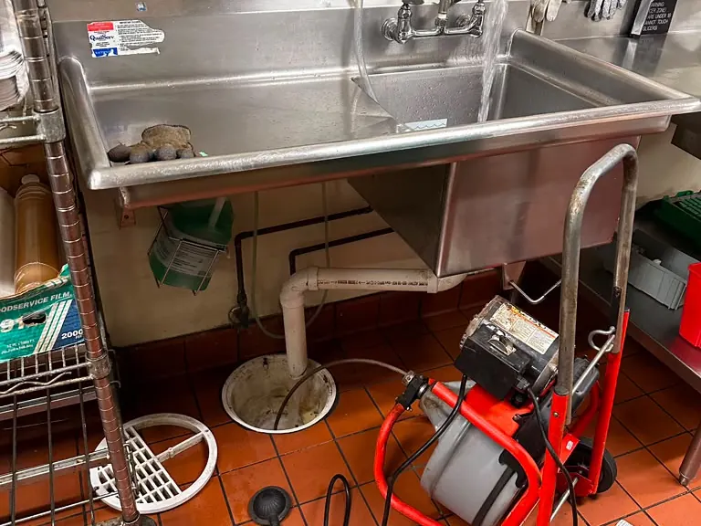 Lumin Drain NJ technician snaking a clogged toilet drain line with a professional cable machine — drain cleaning in Egg Harbor City, NJ
