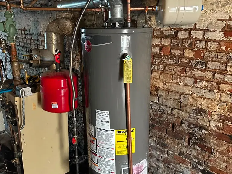 New gas water heater installed in a basement with expansion tank and copper supply lines — Water Heater Installation & Repair in Eatontown