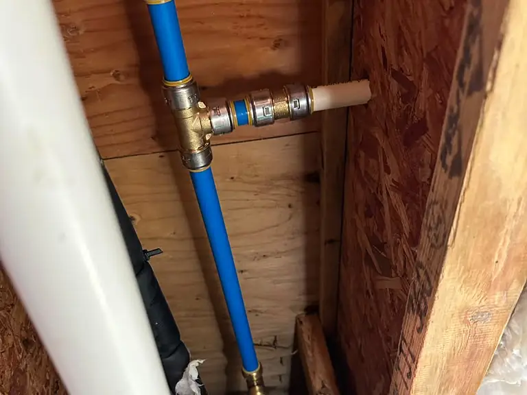 New PEX water line with brass fittings installed through the joists to replace a broken pipe — broken pipe repair in Central New Jersey