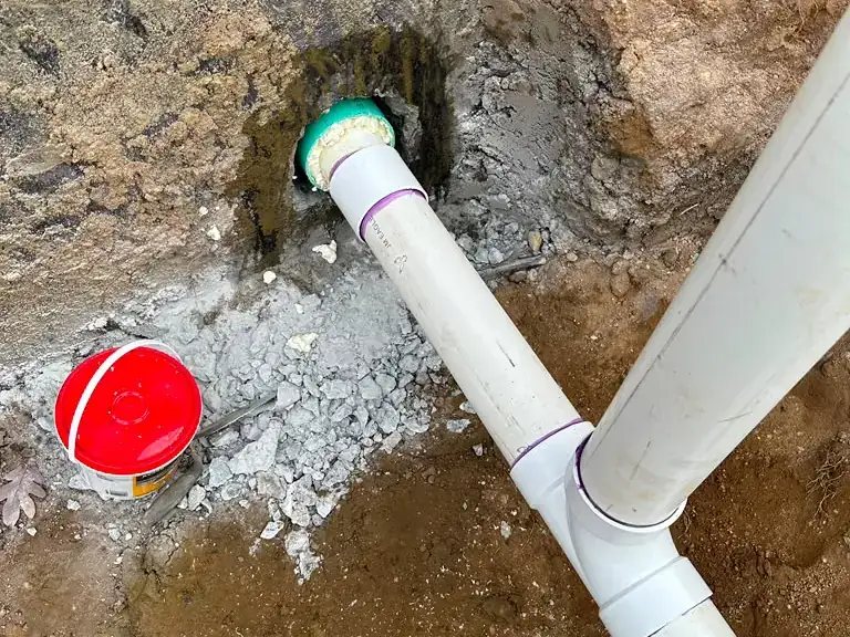 Replacement sewer line connected through the foundation wall with a sealed transition coupling — sewer line repair in Helmetta, NJ