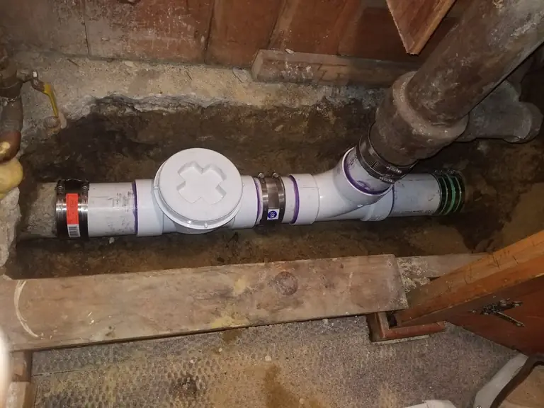 Replaced sewer section with a new cleanout and no-hub couplings joining the existing cast-iron main — sewer line repair in Helmetta, NJ