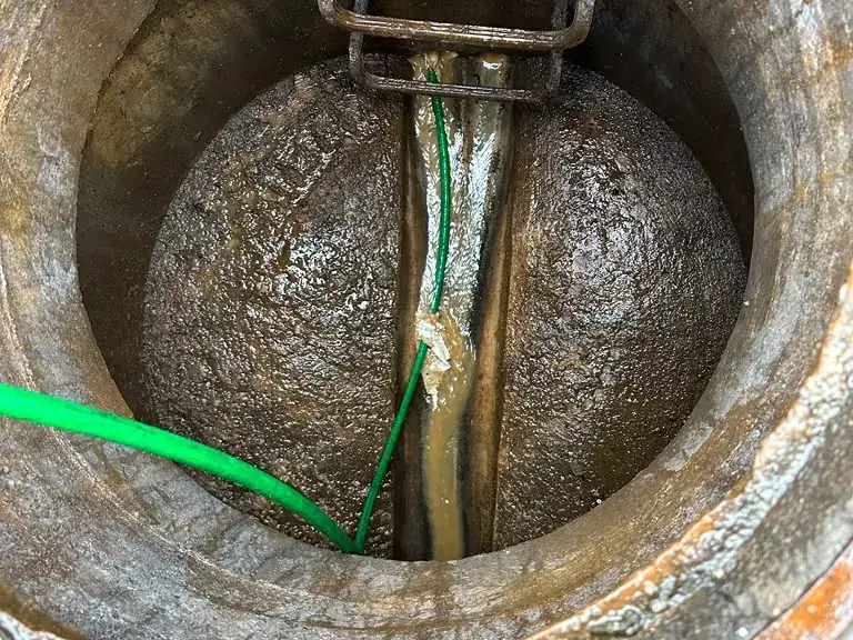 High-pressure jetter hose flushing a municipal sewer line through an open manhole — Hydro Jetting in Eatontown