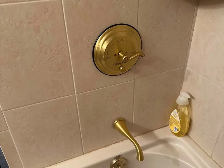 Brushed-gold tub and shower faucet valve trim and spout installed on tile — faucet installation in New Jersey