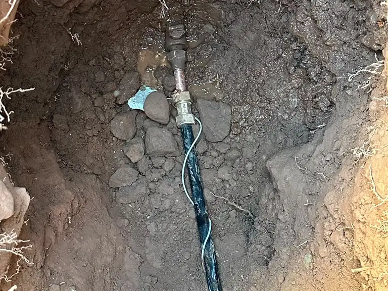 Hand-dug excavation exposing an underground water service line repaired with a new coupling — drain and sewer services across Sussex County, NJ